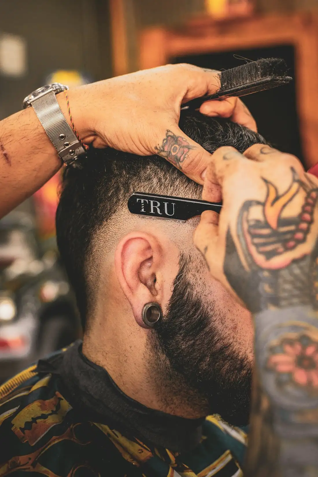 Barber shaping a client's hair with a straight razor